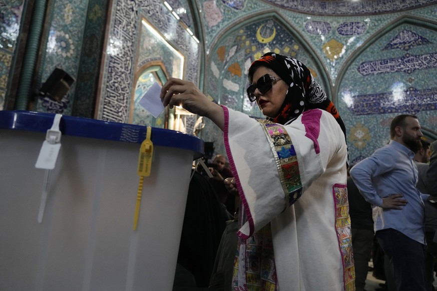 A woman casts her ballot during the presidential election at a polling station in Tehran, Iran, Friday, June 28, 2024. Iranians were voting Friday in a snap election to replace the late President Ebra ...