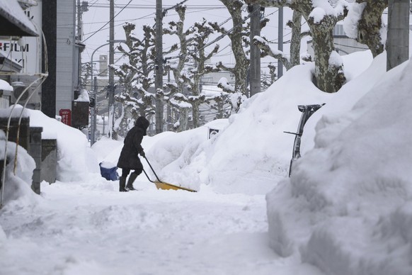 A person removes snow from a street in Aomori, northern Japan Thursday, Jan. 9, 2025. (Kyodo News via AP)