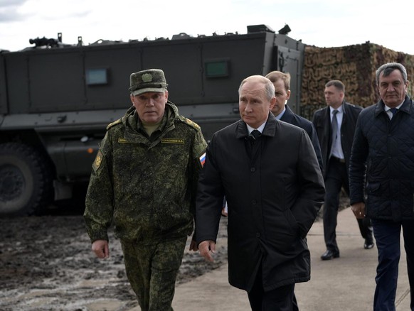 epa07016408 Russian President Vladimir Putin (C) and General of Army Valery Gerasimov (L) attend Russia&#039;s biggest ever military maneuvers, Vostok 2018 (East 2018) on the military range Tsogol, Za ...