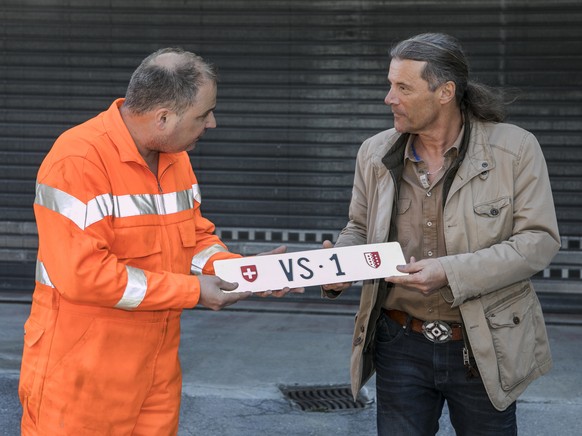 Otto Ruppen, links, nimmt das Autokennzeichen VS 1 von Staatsrat Oskar Freysinger (SVP-VS), rechts, in Empfang und platziert das Nummernschild auf einem Mahnmal vor seiner Ruppen Bau und Transport AG ...
