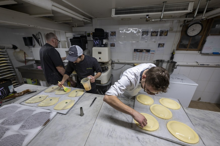 Des employés en plein travail de confection de pâtisseries dans une boulangerie à Genève.