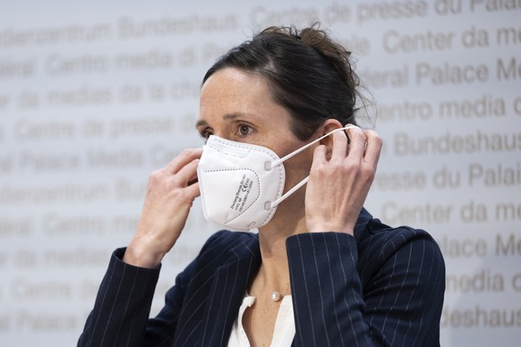 Tanja Stadler, Praesidentin National COVID-19 Science Task Force, zieht eine Maske an, waehrend einer Medienkonferenz zur aktuellen Situation des Coronavirus, am Dienstag, 22. Maerz 2022 in Bern. (KEY ...