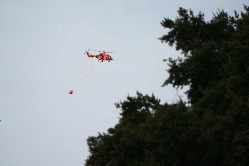 A firefighting helicopter carries water to battle a wildfire in Muriel, Guadalajara province, Spain, Wednesday, July 22, 2026. The blaze scorched tens of thousands of hectares, making it one of Spain& ...