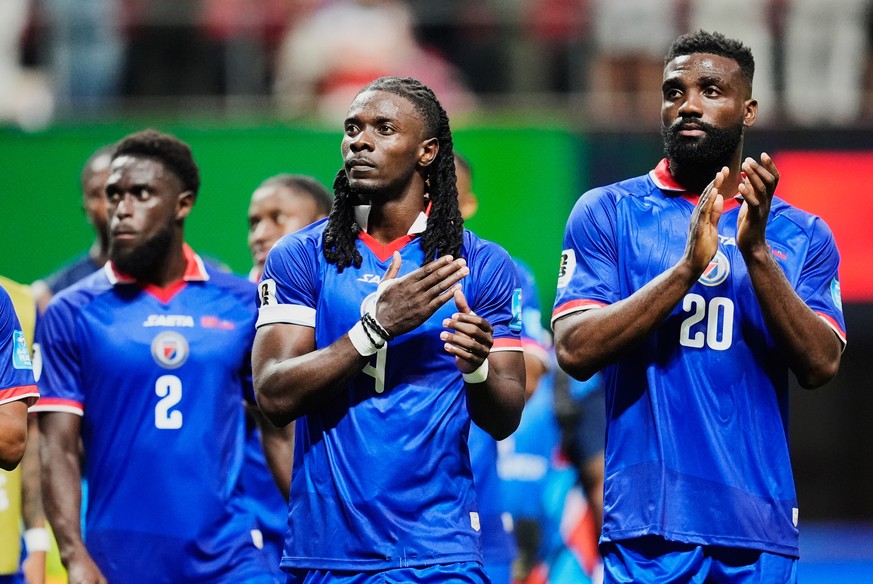 Haiti's Ricardo Ade (4) and Frantzdy Pierrot (20) acknowledge supporters after the World Cup Group C soccer match between Morocco and Haiti in Atlanta, Wednesday, June 24, 2026. (AP Photo/Mike St ...