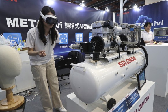 A woman demonstrates the compressor operation from SOP Guidance with AR+AI at the AI Wave Show exhibition in Taipei, Taiwan, Friday, Aug. 1, 2025. (AP Photo/Chiang Ying-ying)
Taiwan AI Wave Show