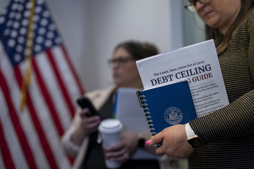 A staffer with the Republican leadership holds a guide to Speaker Kevin McCarthy&#039;s debt ceiling package during a news conference at the Capitol in Washington, Wednesday, April 26, 2023. McCarthy  ...