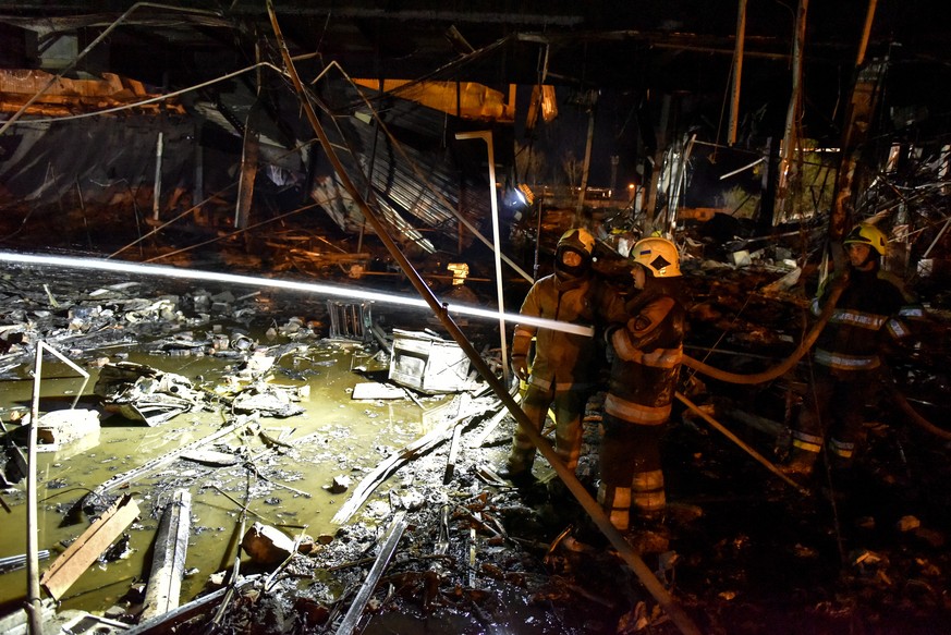 epa10037556 Firefighters and rescue workers clean the rubble of destroyed Amstor shopping mall in Kremenchuk, Poltava Oblast, Ukraine, 27 June 2022. At least eleven bodies were found dead at the scene ...