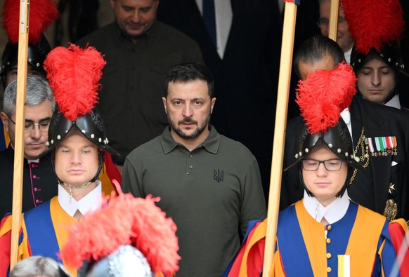 epa11654281 Ukrainian President Volodymyr Zelensky (C) is flanked by Swiss Guards as he leaves after a private audience with Pope Francis (not pictured) at the San Damaso courtyard in the Vatican City ...