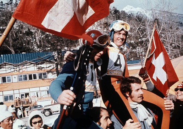 Der Schweizer Abfahrts-Olympiasieger Bernhard Russi (Nr. 4) und der Schweizer Olympiazweite Roland Collombin (Nr. 11) auf den Schultern der Fans an den Olympischen Winterspielen in Sapporo 1972. Die & ...