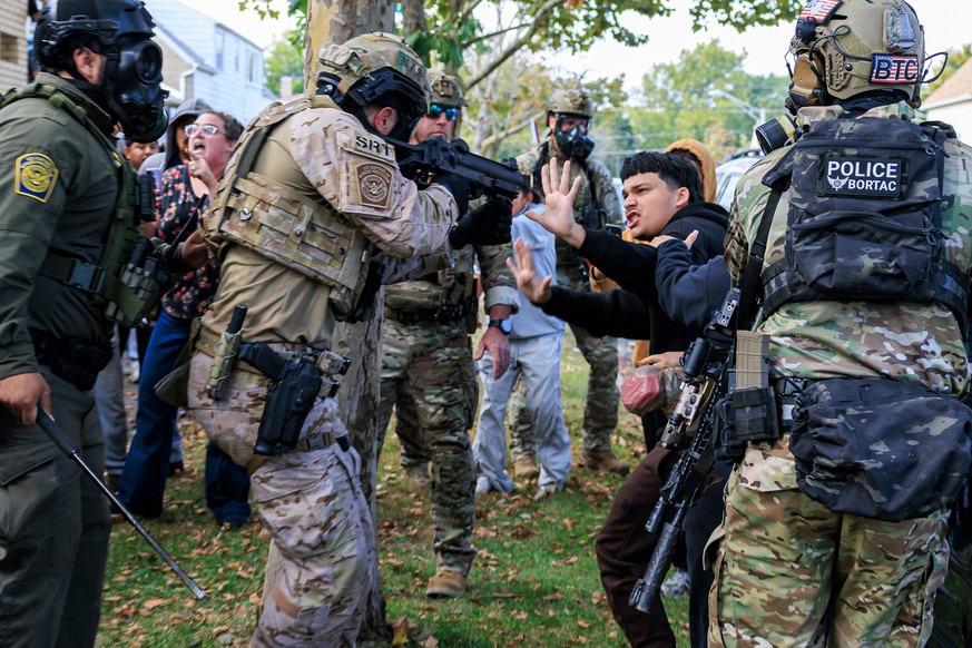 KEYPIX - An ICE agent points a crowd control weapon at a protester in East Side, Chicago, Tuesday, Oct. 14, 2025. (Anthony Vazquez/Chicago Sun-Times via AP)