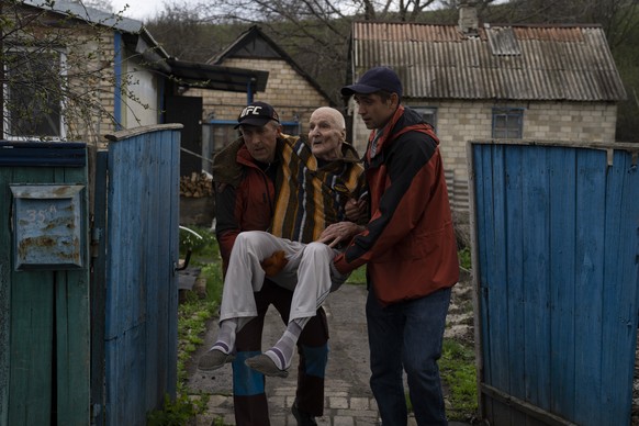 Elderly people are evacuated from a hospice in Chasiv Yar city, Donetsk district, Ukraine, Monday, April 18, 2022. At least 35 men and women, some in wheelchairs and most of them with mobility issues, ...