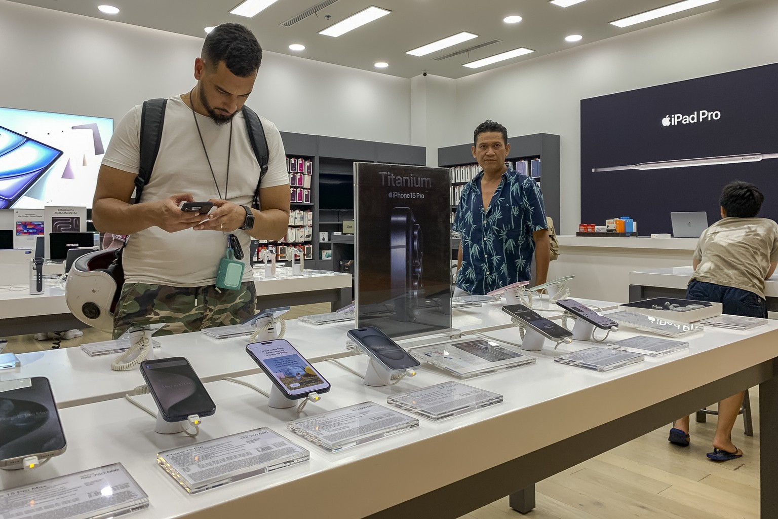 epa11688626 A customer inspects an Apple iPhone 15 at a mall in Denpasar, Bali, Indonesia, 28 October 2024. The Indonesian government has banned the sales of the iPhone 16 due to Apple's failure ...