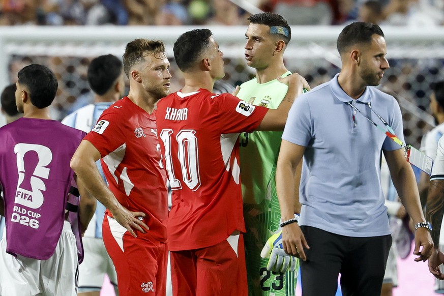 epa13106506 Switzerland's Silvan Widmer (L) and Granit Xhaka (C) talks with Argentina's goalkeeper Emiliano Martinez after the FIFA World Cup 2026 quarterfinals match Argentina vs Switzerlan ...