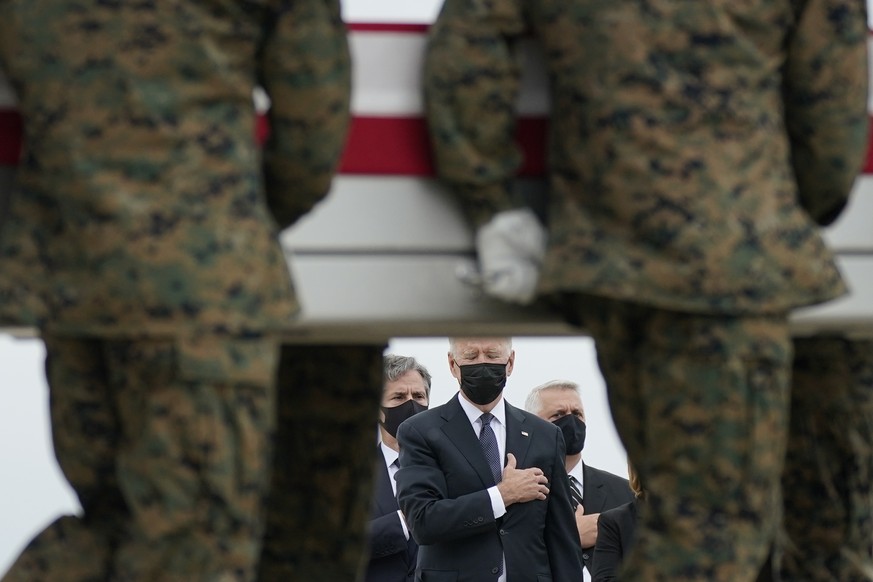 FILE - President Joe Biden watches as a carry team moves a transfer case containing the remains of Marine Corps Lance Cpl. Kareem M. Nikoui, 20, of Norco, Calif., during a casualty return, Aug. 29, 20 ...