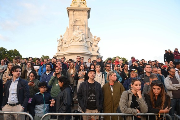 epa10171156 People on the steps of the Queen Victoria Memorial following the official announcement of the death of Queen Elizabeth II, London, Britain, 08 September 2022. According to a statement issu ...