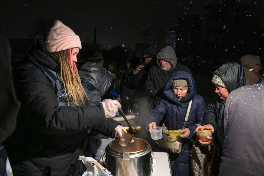 Les membres de la Communauté Sant'Egidio distribuent des repas chauds aux personnes âgées et aux personnes dans le besoin, dans un quartier résidentiel de Kiev pendant la grave crise énergétique.