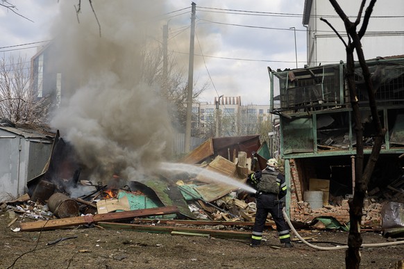 epa11264345 Ukrainian rescue services work at the site of a rocket attack on a residential area in Kharkiv, northeastern Ukraine, 07 April 2024, amid the Russian invasion. At least four people were wo ...