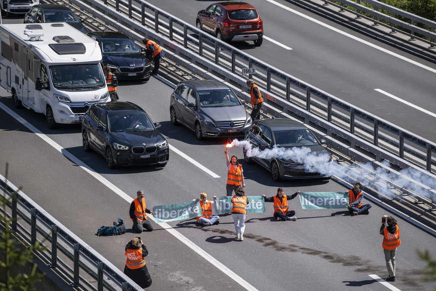 Aktivisten von &quot;Renovate Switzerland&quot; protestieren vor dem Gotthard Tunnel bei Goeschenen im Kanton Uri, weahrend dem sich der Auffahrt Reiseverkehr vor dem Gotthard Nordportal auf mehrere K ...