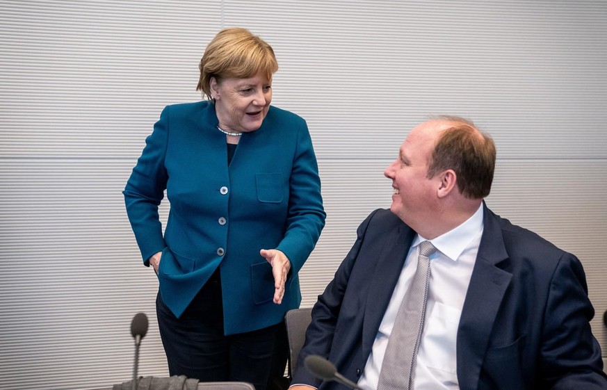 Angela Merkel, à gauche, en pleine discussion avec son ancien chef de cabinet Helge Braun, à droite, candidat à la direction du parti CDU.