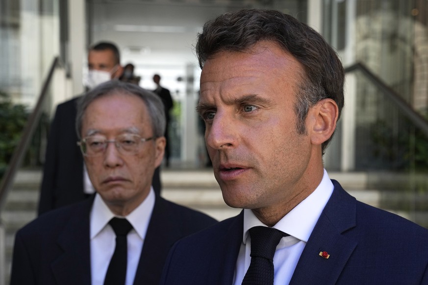 French President Emmanuel Macron and Japan&#039;s ambassador to France Ihara Junichi answers reporters outside at the residence of Japan&#039;s ambassador to France in Paris, Monday July 11, 2022. Fre ...