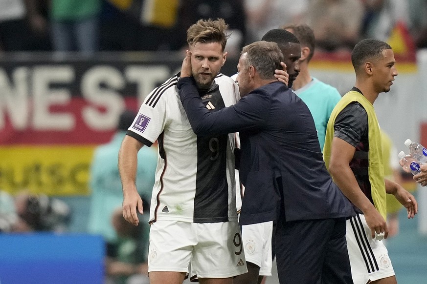 Germany's head coach Hansi Flick embraces Niclas Fuellkrug after he scored their side's first goal during the World Cup group E soccer match between Spain and Germany, at the Al Bayt Stadium in Al Kho ...