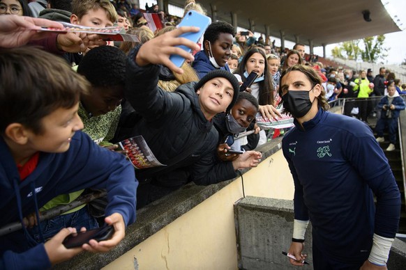 Switzerland national team goalkeeper Yann Sommer, right, takes selfie with fans after a training session for the upcoming 2022 FIFA World Cup European Qualifying Group C match between Switzerland and  ...