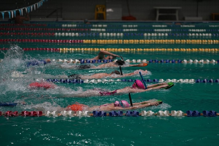 Sur cette photo prise le 17 octobre, des habitants et des enfants nagent dans la plus grande piscine de Kharkiv, qui a été endommagée à plusieurs reprises par des bombardements.