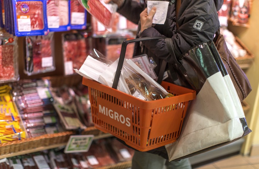 A customer with a shopping basket takes a meat product from the shelf, pictured on March 5, 2013, at the Migros branch in Baden, Switzerland. Migros is Switzerland&#039;s the largest retail company. ( ...