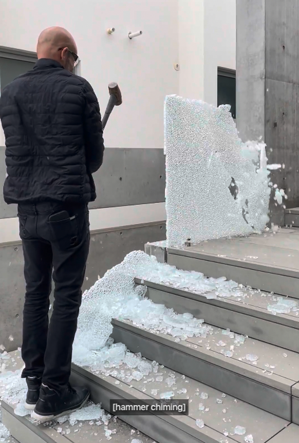 Un ouvrier en train de détruite une balustrade en verre, sur la maison de Malibu Road.