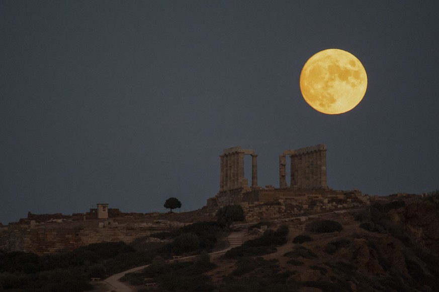 The sturgeon full moon rises behind the ancient Greek marble temple of Poseidon at Cape Sounion, about 70 Km (45 miles) south of Athens, Saturday, Aug. 21, 2021. On Sunday, more than a hundred archeol ...