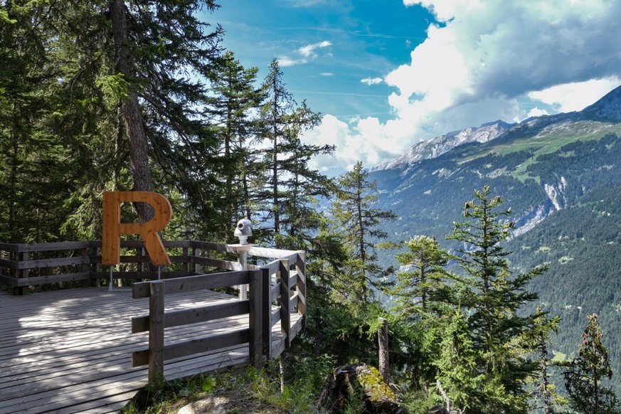 Plate-forme d&#039;observation avec la grande lettre R au début du sentier pédestre du Bisse du Ro près de Crans Montana.