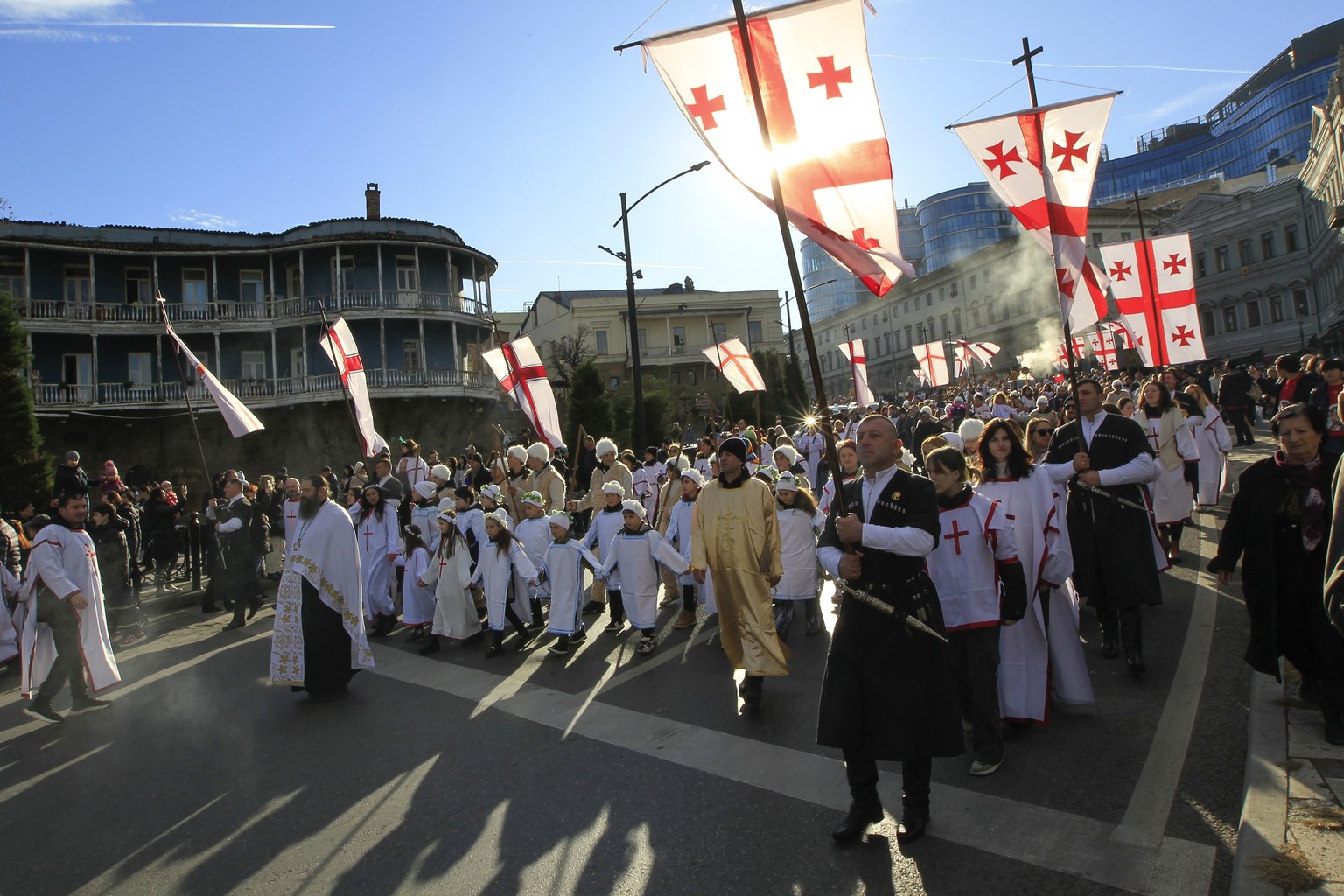 Georgians carry national flags as they take part in a religious procession to mark Orthodox Christmas in the Old Town of Tbilisi, Georgia, Sunday, Jan. 7, 2024. While much of the world has Christmas i ...