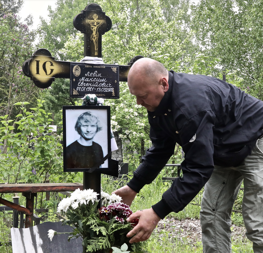 Aleksandr Levin déposant des fleurs sur la tombe de son frère Max, à Boyarka, le 30 mai 2022.