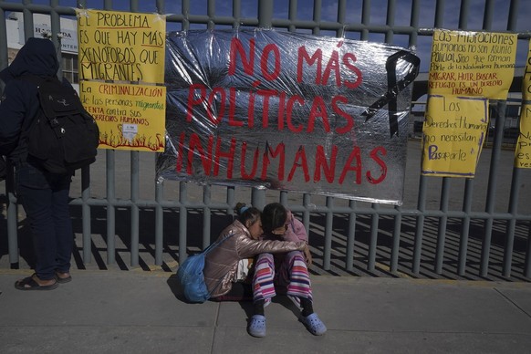 A pair of Venezuelan sisters comfort each other sitting on a sidewalk outside an immigration detention center where dozens of migrants fearing deportation set mattresses ablaze, starting a fire that k ...