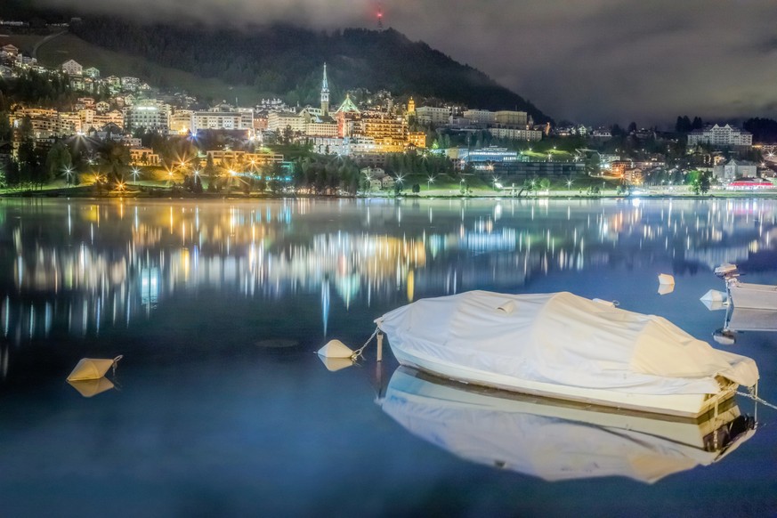 St Moritz illuminated cityscape and lake reflection at night, Engadine, Swiss alps, Switzerland