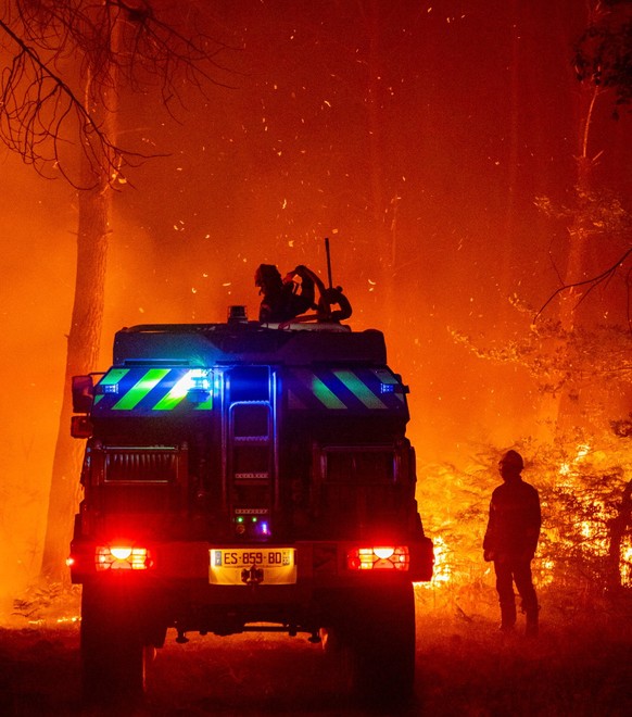 epa10075818 A handout picture made available by the Gironde Fire and Rescue Departmental Service 33 (SDIS 33) shows firefighters trying to extinguish flames at forest fire in La Teste-de-Buch, France, ...