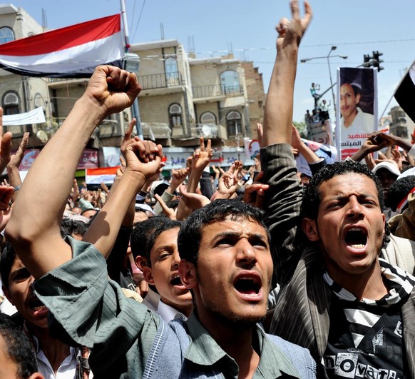 epa02644646 Yemeni anti-government protesters shout slogans during a protest in Sana&#039;a, Yemen, on 20 March 2011. Huge crowds joined burial procession of some of the victims, as about 50 people di ...