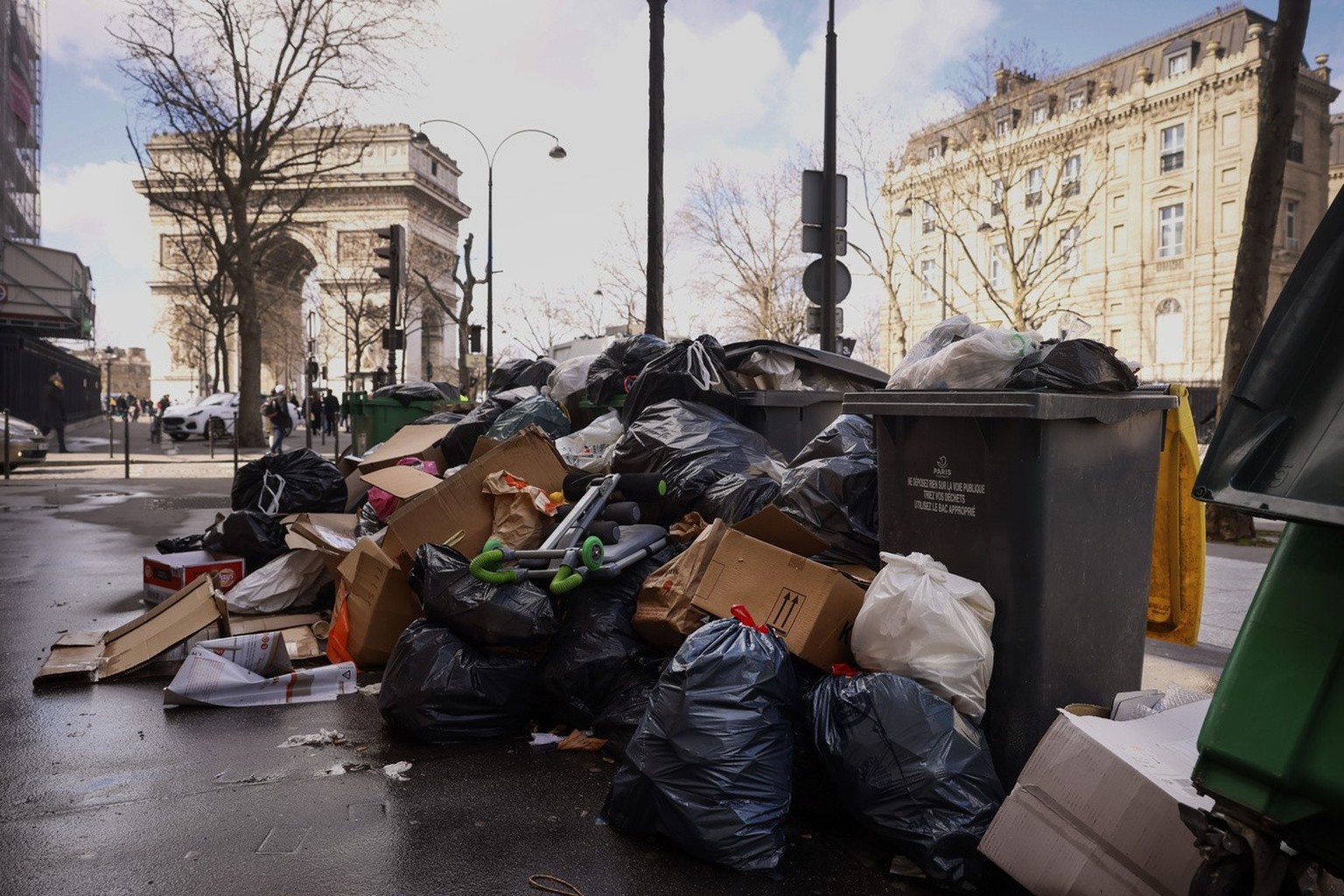 Uncollected garbages are pictured near the Arc de Triomphe in Paris, Tuesday, March 14, 2023. The City of Light is losing its luster with tons of garbage piling up on Paris sidewalks as sanitation wor ...