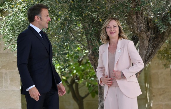 epa11407584 Italy's Prime Minister Giorgia Meloni (R) greets French President Emmanuel Macron (L) during a welcome ceremony for the G7 summit in Borgo Egnazia, southern Italy, 13 June 2024. The 5 ...