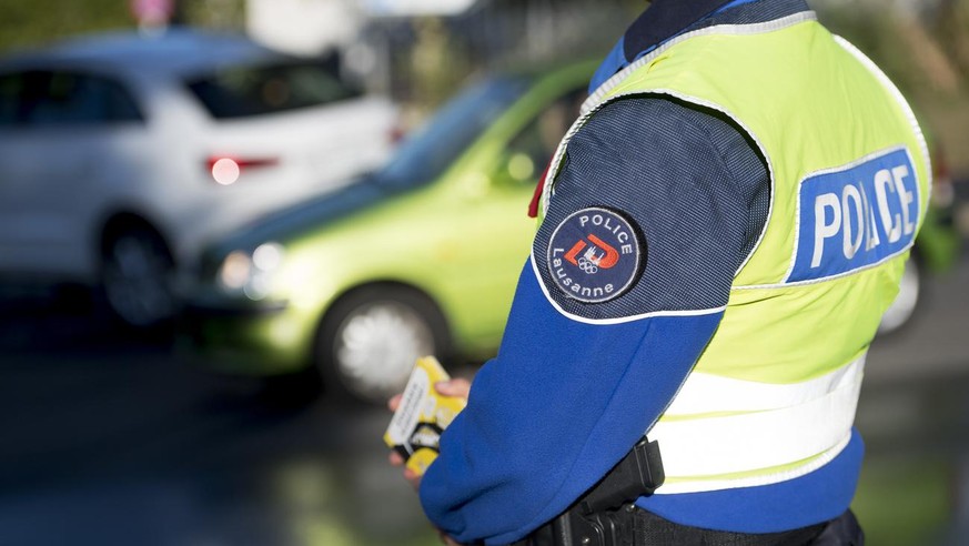 Un policier de la Police de Lausanne effectue un controle d'une voiture lors de la campagne de prevention routiere pour la rentree scolaire 2018 ce lundi 27 aout 2018 a Lausanne. A l'occasion de la re ...