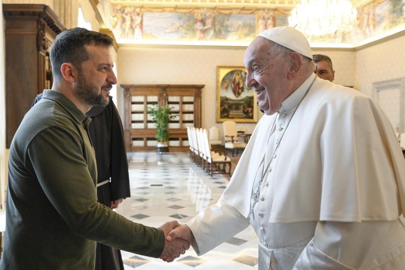 epa11654671 A handout picture provided by the Vatican Media shows Pope Francis (R) and Ukrainian President Volodymyr Zelensky shaking hands during a private audience in the Vatican City, 11 October 20 ...