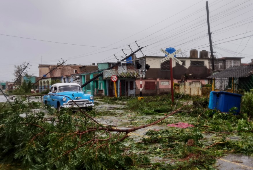epa10210512 A car drives through debris on the street after the passage of Hurricane Ian, in Pinar del Rio, Cuba, 27 September 2022. Ian made landfall in western Cuba as a category 3 hurricane, causin ...