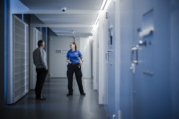 BITTE BEACHTEN SIE DIE SPERRFRIST BIS 30. 03. 2022,17:30 --- Eine Aufseherin spricht mit einem Teilnehmer des Testbetriebs im Gang eines Zellentrakts im Polizei- und Justizzentrum Zuerich (PJZ), waehr ...
