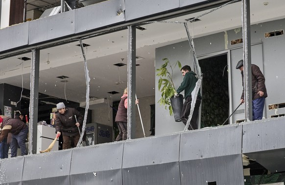 epa11700499 People clean the debris at the site of a Russian glide bomb strike on a residential area in Kharkiv, Ukraine, 04 November 2024, amid the Russian invasion. At least 14 people were injured a ...