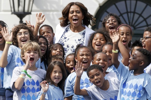 First lady Michelle Obama, a longtime supporter of healthier eating and physical fitness, is surrounded by children as she expands her push for America to drink more water, at a &quot;Drink Up&quot; e ...