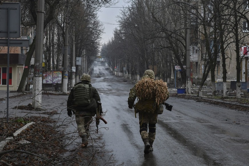 Ukrainian soldiers walk on the street in Bakhmut, the site of the heaviest battles with the Russian troops, in the Donetsk region, Ukraine, Thursday, Dec. 15, 2022. (AP Photo/Andriy Andriyenko)