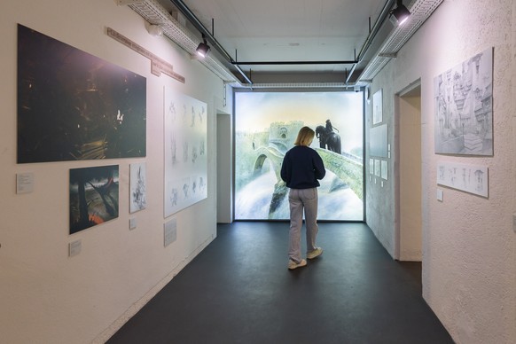 Une personne regarde des oeuvres qui sont exposees lors de l'exposition inaugurale "Voyage dans les mondes de John Howe" ce lundi 15 decembre 2025 a la Tour du Fantastique a Neuchatel.  ...