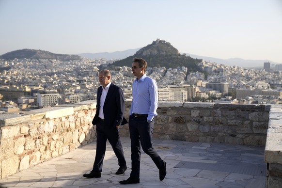Greek Prime Minister Kyriakos Mitsotakis, right, and German Chancellor Olaf Scholz walk at the ancient Parthenon Temple at the Acropolis hill during a visit, in Athens, Thursday, Oct. 27, 2022. Scholz ...