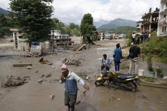 KEYPIX - epa13191982 Villagers wade through flooded streets following a flash flood in Trishuli Bazar, Nuwakot district, Nepal, 26 August 2026. Several people were killed and multiple others were repo ...