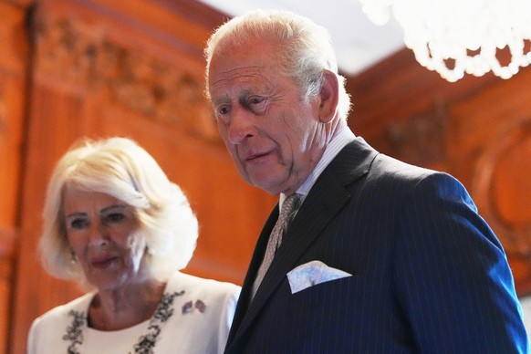Queen Camilla and King Charles III look over items to be placed in a time capsule in honor of the United States' 250th anniversary in the Ambassador's Library room of the British Embassy, Mo ...